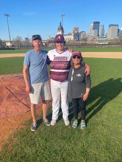 Three people standing on a baseball field